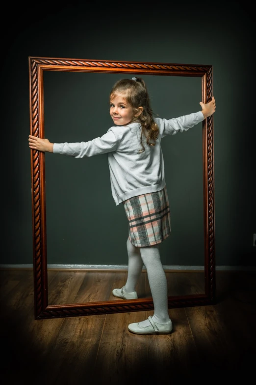a little girl standing in front of a picture frame, a picture, by Hristofor Zhefarovich, surrealism, fun pose, dressed as schoolgirl, big mirrors, funny professional photo