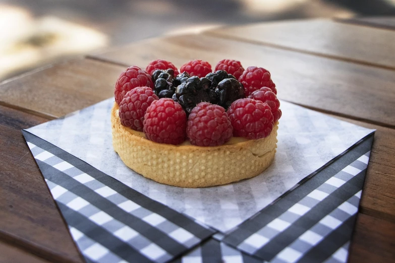 a pastry topped with raspberries and blueberries, inspired by Richmond Barthé, pexels, photorealism, 2 4 mm iso 8 0 0 color, flan, award - winning crisp details ”, lattice