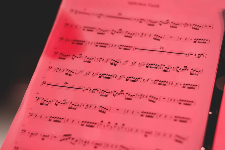 a sheet of music sitting on top of a table, synchromism, red color bleed, transparencies, close look, orchestra