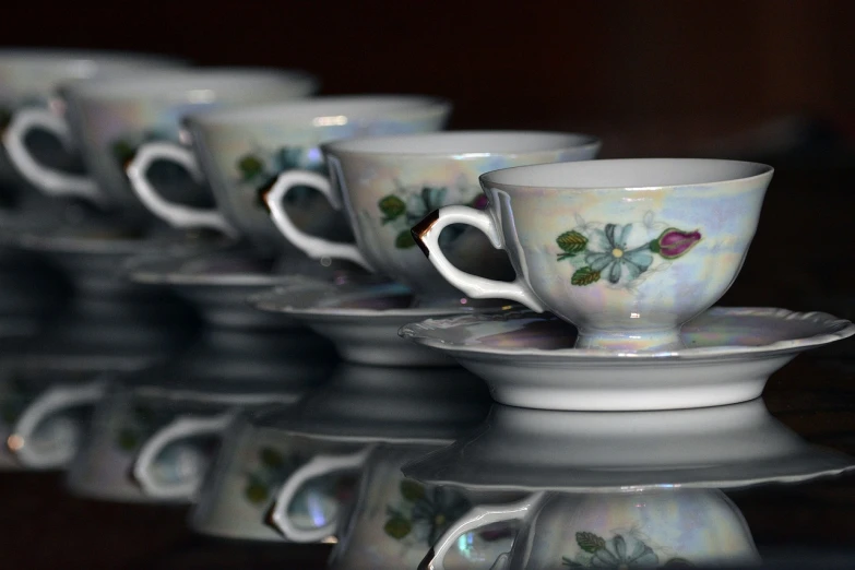 a group of coffee cups sitting on top of a table, a photo, inspired by Anna Füssli, flickr, cloisonnism, beautiful reflexions, closeup photo, opalescent, in a row