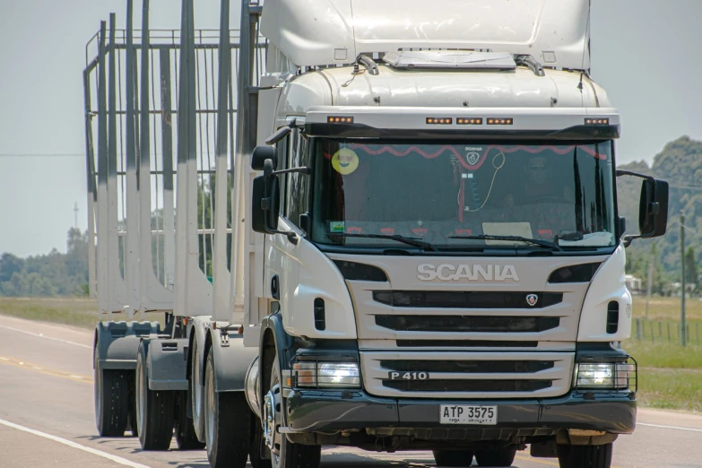 a white semi truck driving down a road, a picture, by Richard Carline, flickr, sao paulo, img _ 9 7 5. raw, good face, hot summer sun