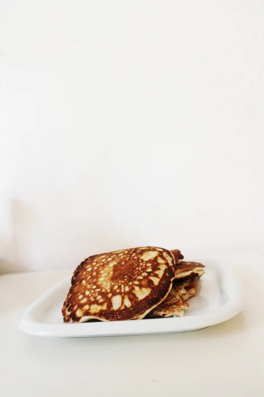 a stack of pancakes sitting on top of a white plate, by Emma Andijewska, dau-al-set, delicate patterned, photo 50mm, slightly sunny, :3