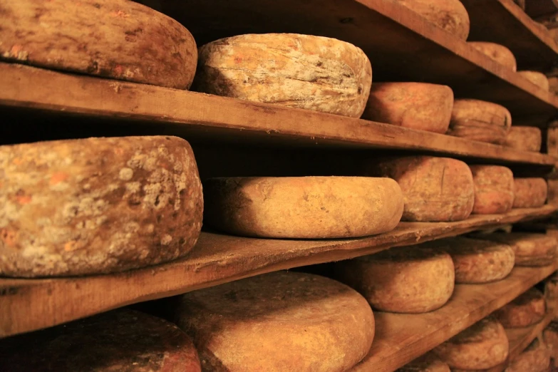 a shelf filled with lots of cheese on top of wooden shelves, shutterstock, renaissance, agrigento, seen from below, well worn, onyx