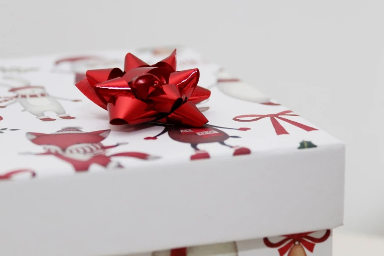 a white box with a red bow on top of it, a picture, inspired by Rudolph F. Ingerle, pexels, wallpaper mobile, wrapped, glossy white, wallpaper - 1 0 2 4