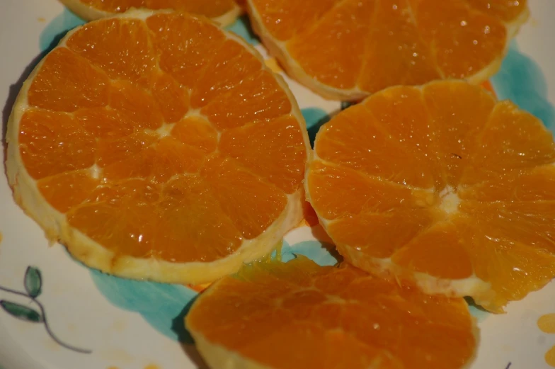 a close up of orange slices on a plate, inspired by Masamitsu Ōta, process art, jelly - like texture, low quality photo, high res photo, ready to eat