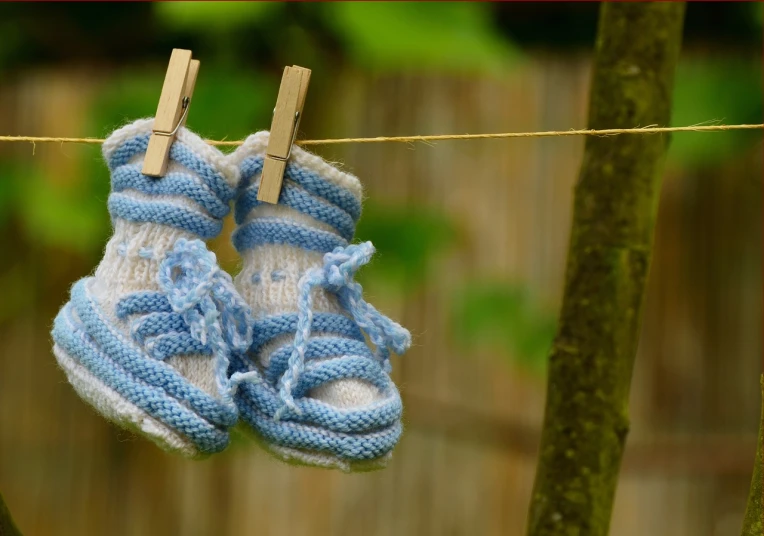 a pair of baby shoes hanging on a clothes line, by Alexander Brook, pixabay, realism, blue soft details, avatar image, socks, no words 4 k