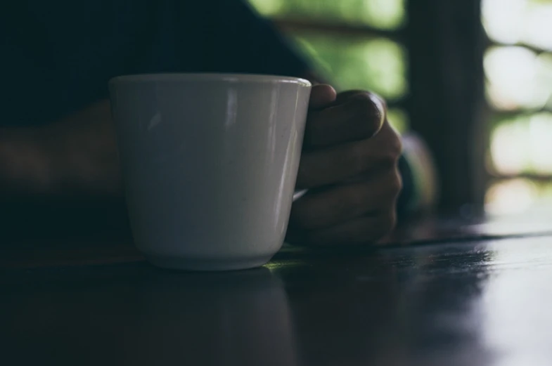 a close up of a person holding a coffee cup, by Karl Buesgen, unsplash, realism, sitting alone, kodakchrome : : 8 k, shaded, end of the day