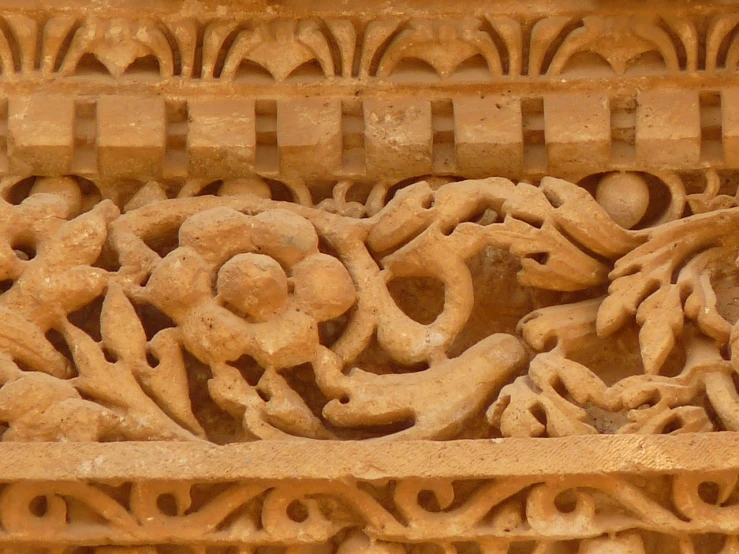 a close up of a carving on a building, inspired by Kamāl ud-Dīn Behzād, flickr, arabesque, flower motif, khajuraho, thorns and vines. detailed, inside stylized border