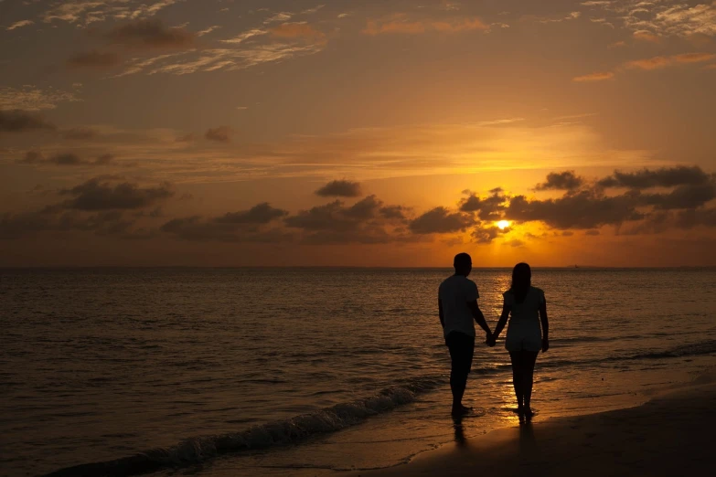 a couple holding hands on the beach at sunset, a picture, afp, aruba, video, sandra