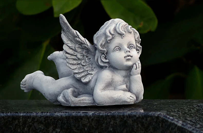 a statue of an angel sitting on top of a table, a statue, by Marie Angel, pixabay, concrete art, cute decapodiformes, lying on the ground, highly detailed product photo, marble!! (eos 5ds r