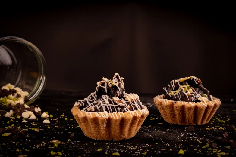 a couple of cupcakes sitting on top of a table, by Aleksander Gierymski, in front of a black background, food photography 4 k, pie eyes, stroopwaffel