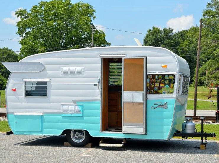 a blue and white trailer parked in a parking lot, a colorized photo, shutterstock, seafoam green, cut-away, fully decorated, window open