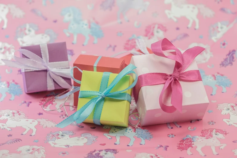 a couple of gift boxes sitting on top of a table, pixabay, unicorns, bows, pink color scheme, portra 8 0 0 ”