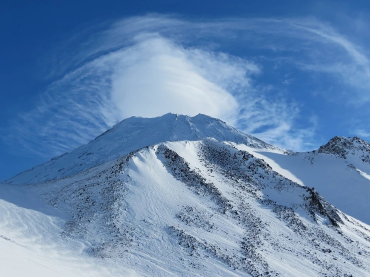 a man riding skis down a snow covered slope, a picture, by Andrei Kolkoutine, shutterstock contest winner, surrealism, horizon of an erupting volcano, whorl. clouds, climbing mountain in washington, hq 4k phone wallpaper