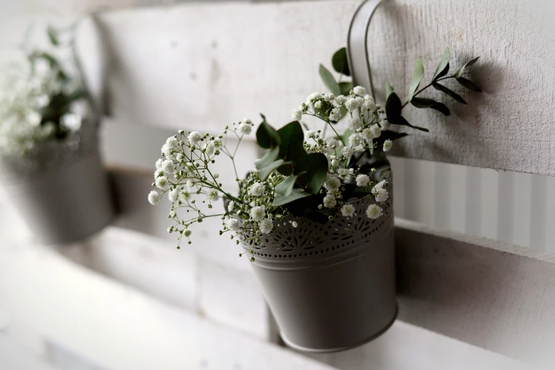 a close up of a flower pot on a wall, by Sylvia Wishart, unsplash, silver，ivory, wooden decoration, gypsophila, romantic greenery