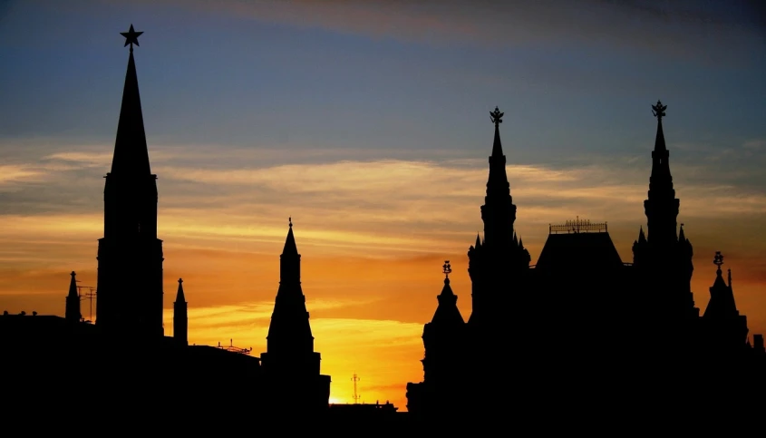 a silhouette of a building with spires at sunset, by Serhii Vasylkivsky, flickr, moscow kremlin is on fire, large twin sunset, view from the side”, washington dc