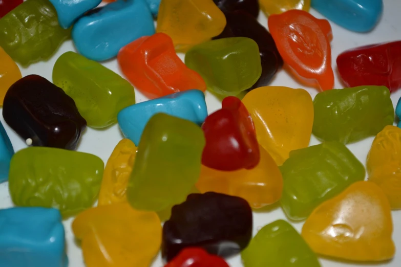 a pile of gummy bears sitting on top of a table, by Ella Guru, hurufiyya, solid coloured shapes, ultrafine detail ”, all teeth, seventies