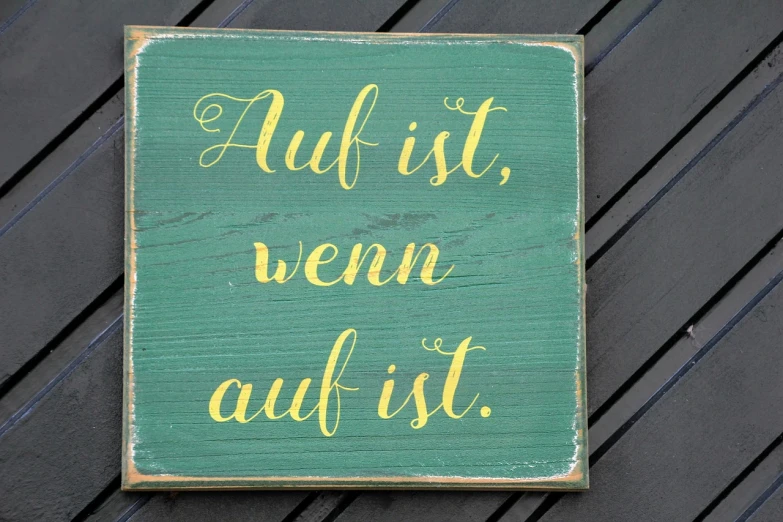 a green sign sitting on top of a wooden table, inspired by August Querfurt, arbeitsrat für kunst, green and gold, saying, dau - al - set, etsy