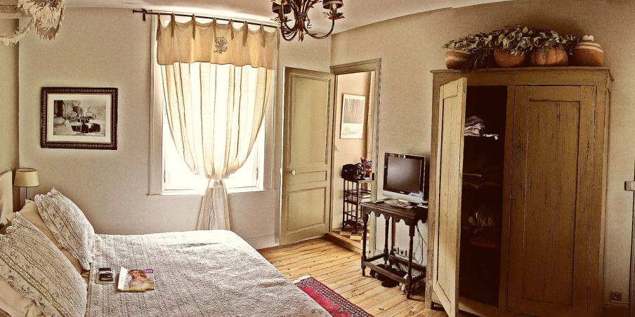 a bed room with a neatly made bed and a chandelier, inspired by Jean-Baptiste-Camille Corot, flickr, art nouveau, doors to various bedrooms, warm sunshine, retro style ”