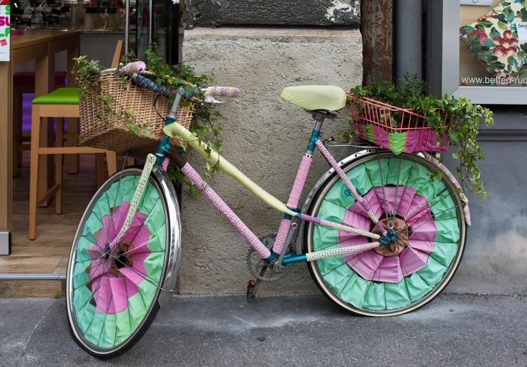 a pink and green bicycle parked next to a building, by Murakami, flickr, renaissance, clothes made out of flower, made of swiss cheese wheels, italy, flash photo