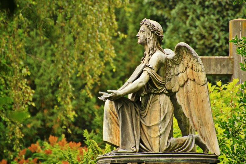 a statue of an angel sitting on top of a cross, pixabay, art nouveau, during autumn, weeping angels, photo of a beautiful, feathered wings