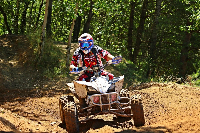 a man riding on the back of a dirt bike, a photo, all terrain vehicle race, laura sava, summer season, action shots