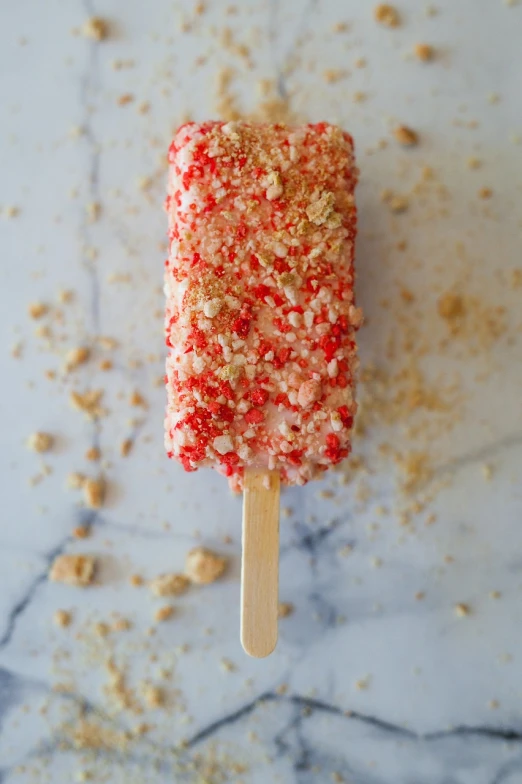 a popsicle covered in red and white sprinkles, square, kali, full-shot, coral