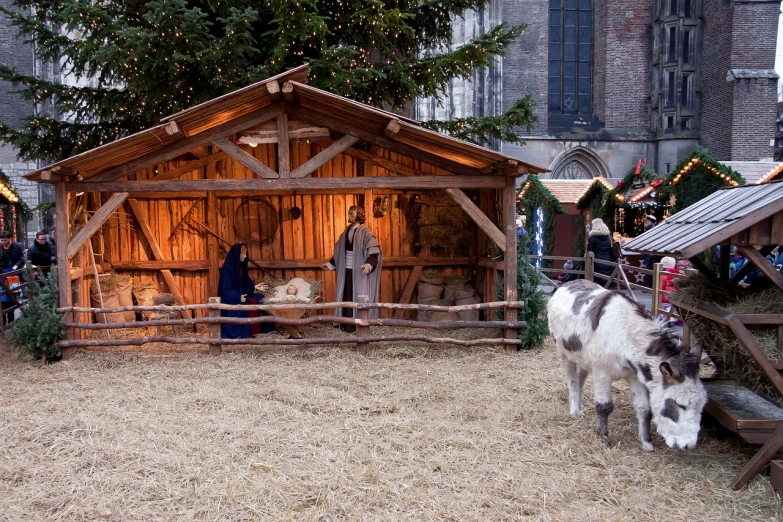 a group of people standing around a wooden structure, a photo, by Salomon van Abbé, pexels, renaissance, christmas night, goat, large diorama, where a large