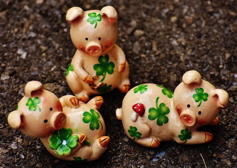 three little pig figurines sitting on the ground, a photo, trending on pixabay, folk art, background full of lucky clovers, tan, pvc figurine, handpainted