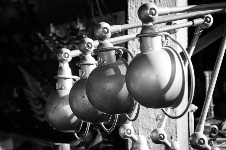 a black and white photo of a bunch of pots, by Etienne Delessert, kinetic art, bells, hdr detail, morning sun, carbide lamp
