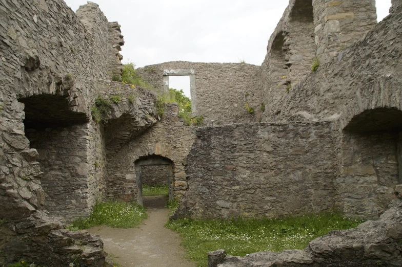 a stone building with a doorway in the middle of it, by Edward Corbett, flickr, romanesque, intricate castle interior, overgrown ruins, bartlomiej gawel, courtyard walkway