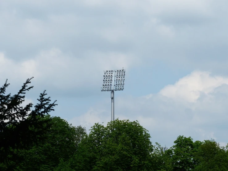 a baseball field with a light tower in the background, by Werner Gutzeit, hurufiyya, summer lighting, wikimedia, view from bottom to top, with vegetation