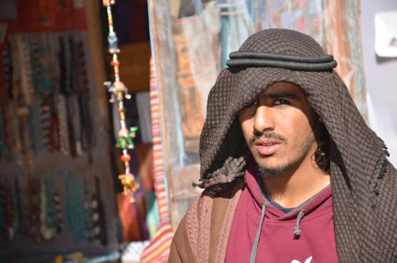 a close up of a person wearing a hat, inspired by Bouchta El Hayani, old jeddah city street, avatar image, a young man, luxor