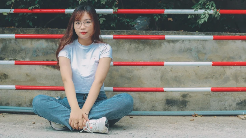 a woman sitting on the ground with her legs crossed, by Tan Ting-pho, unsplash, realism, kawaii shirt and jeans, wearing small round glasses, portait photo profile picture, low quality grainy