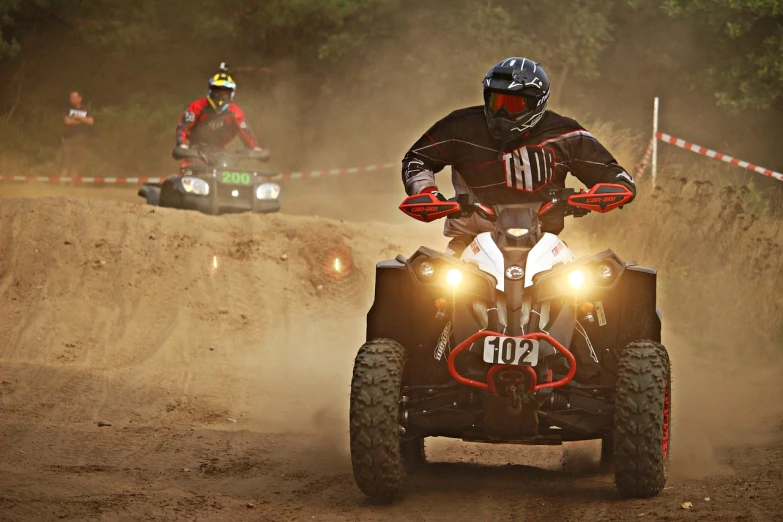 a couple of people riding atvs down a dirt road, a photo, by Matija Jama, shutterstock, figuration libre, in a race competition, lighting, university, interesting background