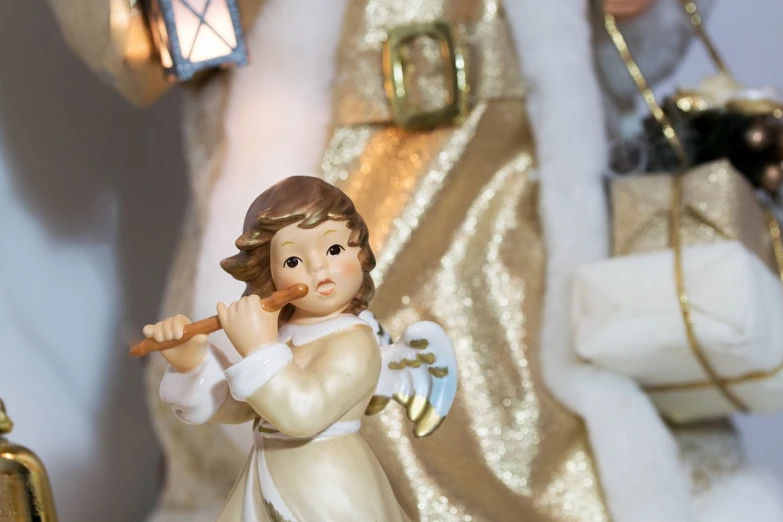 a figurine of an angel holding a baseball bat, a portrait, inspired by Louis Le Nain, pexels, baroque, christmas night, white and gold color scheme, medium close shot, santa