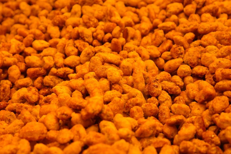 a pile of fried food sitting on top of a table, a macro photograph, hurufiyya, peanuts, yellow-orange, high quality product image”
