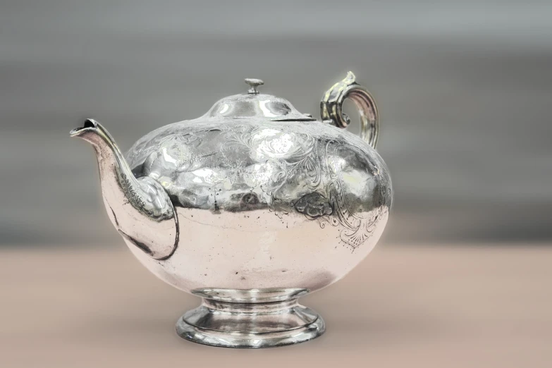 a silver tea pot sitting on top of a table, by Jan Kupecký, pixabay, art nouveau, engraved texture, museum quality photo, high detail 4k render, england