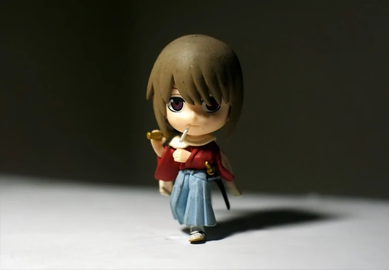 a close up of a figurine on a table, pixiv, mingei, rurouni kenshin, macro 8mm photo, okita sougo, standing!!