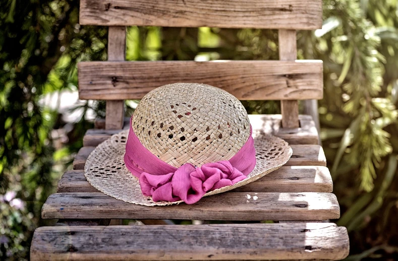 a straw hat sitting on top of a wooden chair, by Henrik Weber, pixabay contest winner, pink headband, sitting on a park bench, gardening, feminine looking