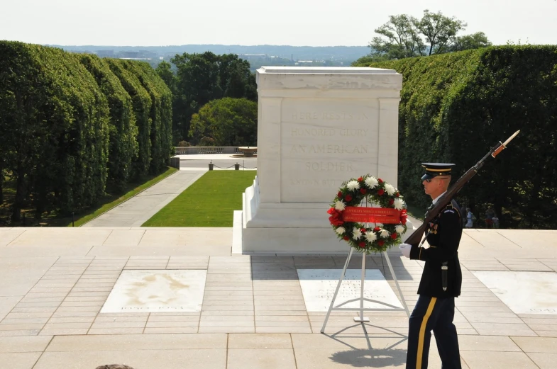 a man in uniform standing in front of a wreath, by Douglas Shuler, flickr, inside a tomb, overlooking, usa-sep 20, vine