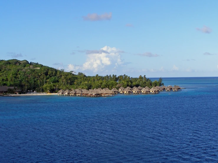 a small island in the middle of the ocean, a photo, by Dietmar Damerau, flickr, hurufiyya, huts, mami wata, sweeping vista, with vegetation