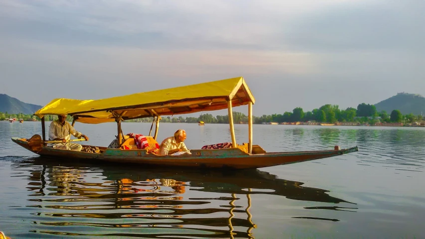 a group of people riding on top of a boat, by Shekhar Gurera, on the calm lake, gondola, golden glow, fully covered