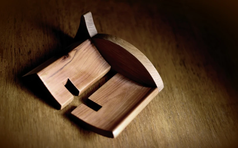 a wooden box sitting on top of a wooden table, an abstract sculpture, deviantart, mingei, smooth curvilinear design, close-up from above, pews, clogs