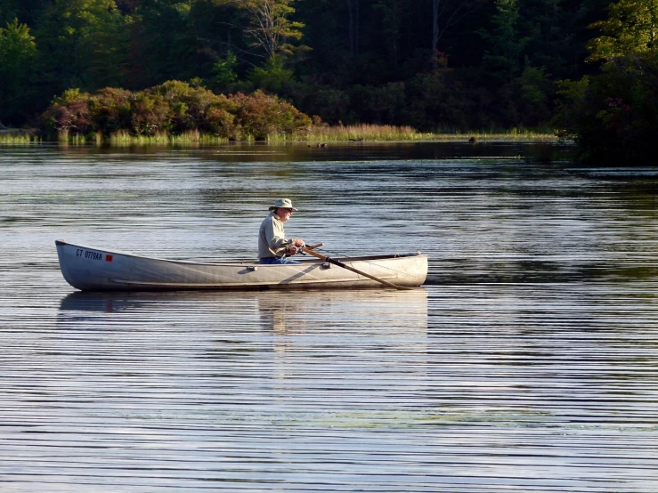 a man in a canoe on a lake, by Jim Nelson, flickr, dappled in evening light, craigville, working hard, fishing