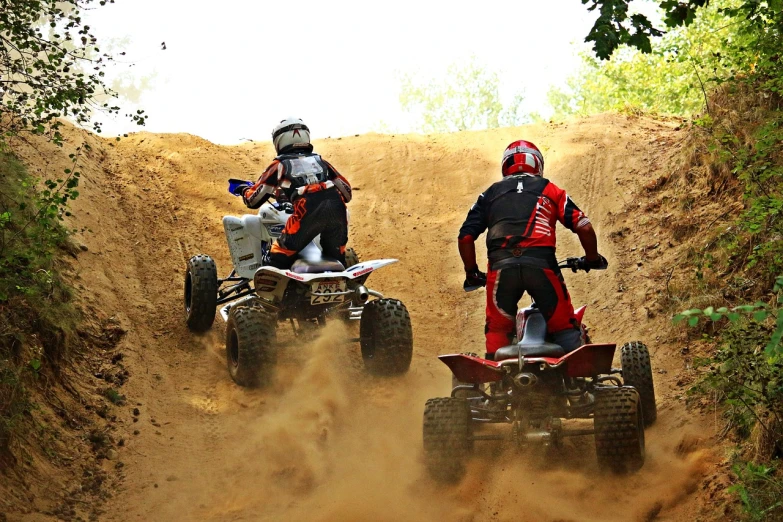 a couple of people riding atvs down a dirt road, a photo, figuration libre, action sports, wallpaper!, in an arena pit, taken with my nikon d 3