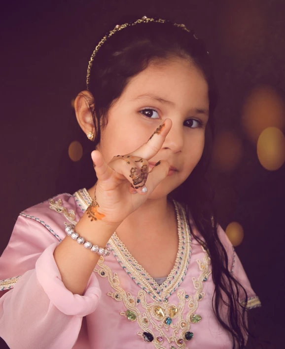 a little girl that is holding something in her hand, by Riza Abbasi, art photography, arabian night, hand on cheek, full res, lowres