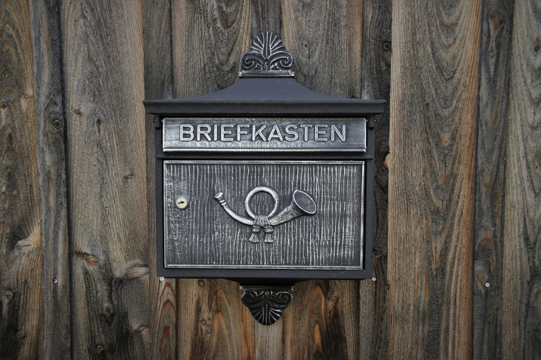 a mailbox sitting on the side of a wooden fence, inspired by Emil Bisttram, flickr, letterism, sleipnir, cast iron material, krakens, in style of chrome hearts