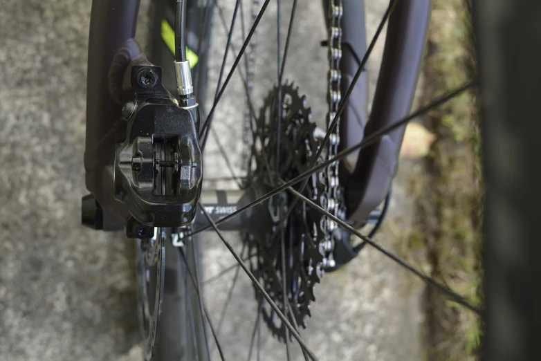 a close up of the front wheel of a bicycle, realism, close-up shot from behind, high detail photo, black gears, high details photo