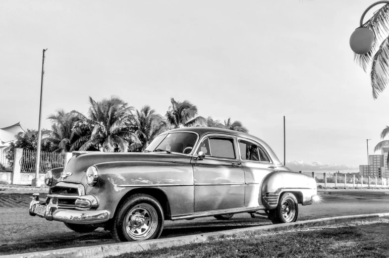 an old car is parked on the side of the road, a portrait, by Sven Erixson, pexels contest winner, fine art, 4k greyscale hd photography, cuban setting, late afternoon, shiny silver